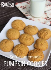 Soft pumpkin cookies on a plate with a napkin and glass of milk.
