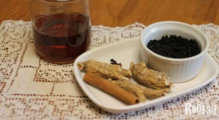 herbs on white plate and brandy for making elderberry cordial