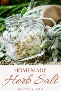 An open square shaped jar full of salt and dried herbs, surrounded by fresh herbs with a text block reading: homemade herb salt.