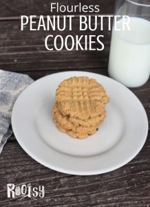 Flourless Peanut Butter Cookies stacked on a plate with a glass of milk.