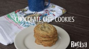 Gluten free chocolate chip cookies stacked on a plate with a napkin and cup of coffee.