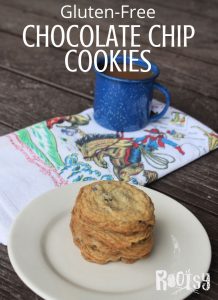 Gluten free chocolate chip cookies stacked on a plate with a napkin and cup of coffee.