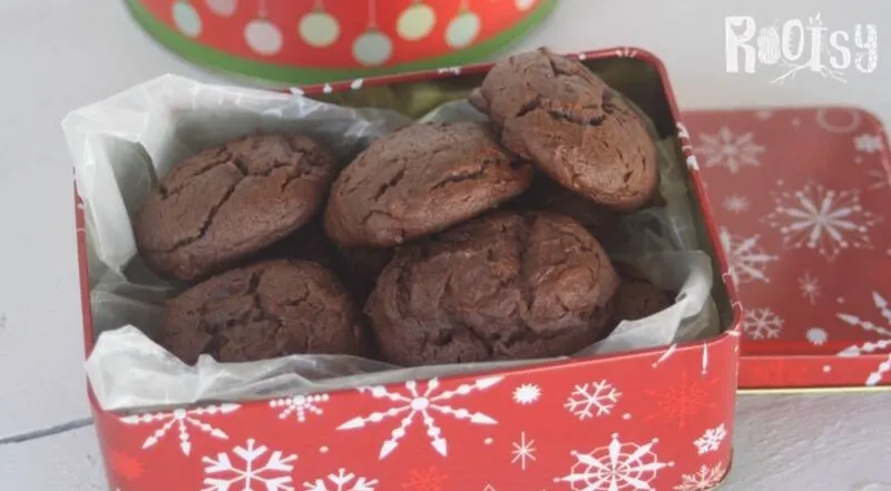 chocolate cookies in a red tin with white snowflakes.