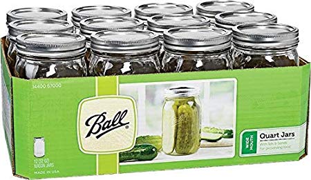 A packaging box contains twelve Ball brand quart-sized mason jars with silver lids, perfect for gifts in a jar. The green box showcases an image of pickles and the text "Quart Jars," highlighting their ideal use for preserving and pickling.
