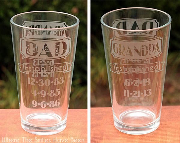 Two pint glasses with etched designs. The left glass reads "Dad" with dates, and the right glass reads "Grandpa" with dates. Both have "Established" followed by birth, marriage, and children's birth dates.