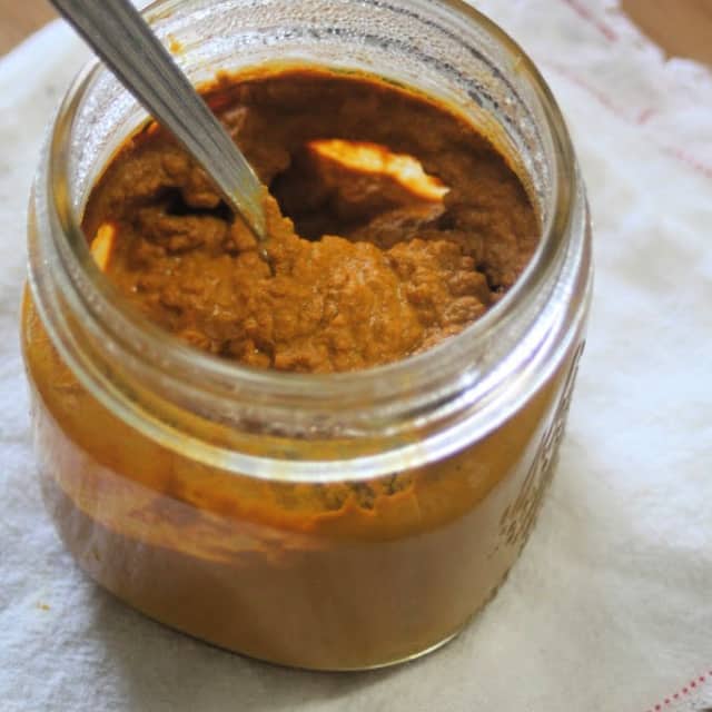 Golden milk paste in a jar with spoon.