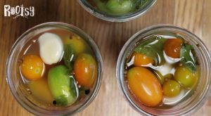 cherry tomatoes and garlic with spices in mason jars for fermenting