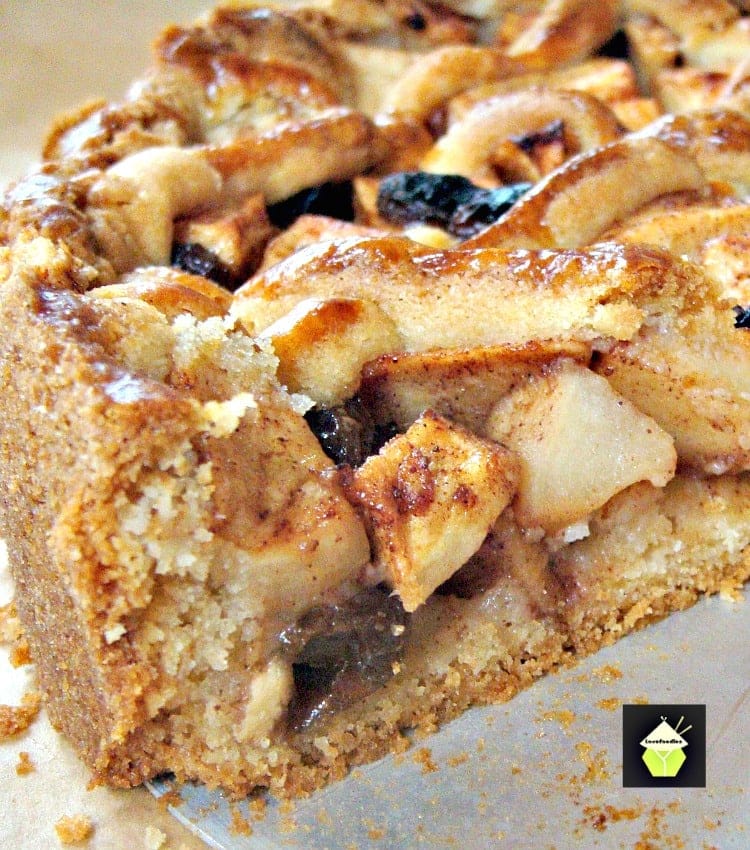 A close-up of a partially sliced apple pie showcases its golden-brown lattice crust and visible chunks of apple filling, dusted with cinnamon—a classic delight in the world of apple recipes.