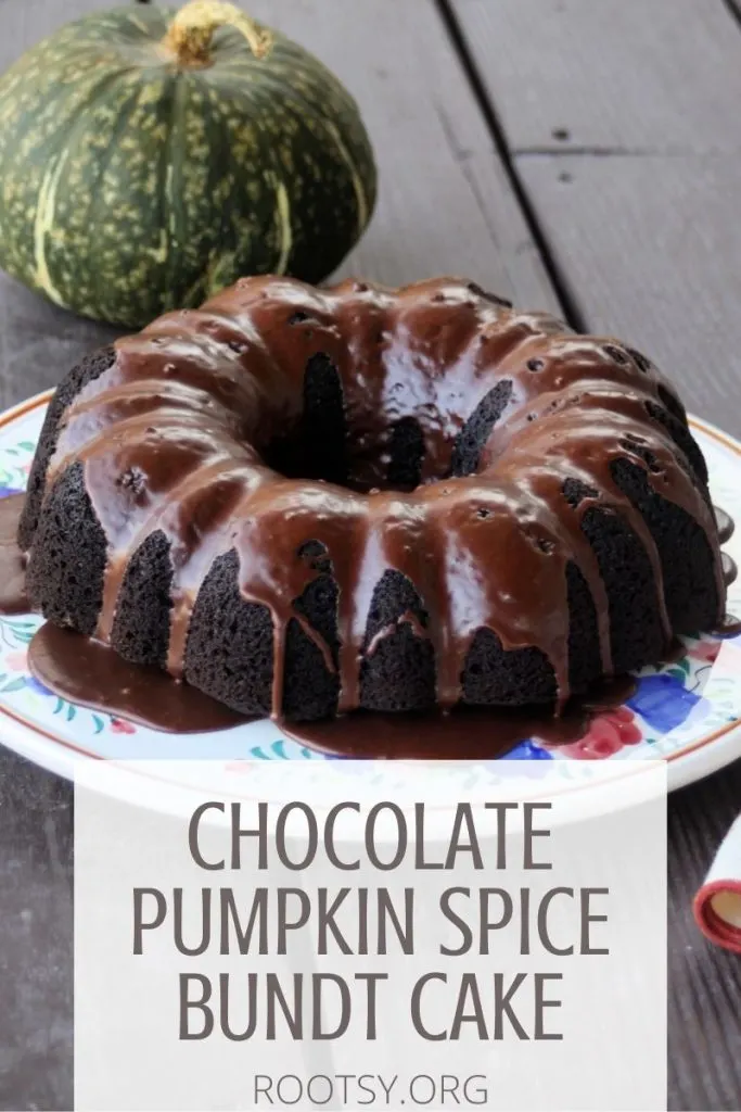 A glazed chocolate pumpkin cake on a floral cake plate with green pumpkin sitting behind it with text overlay reading chocolate pumpkin spice bundt cake.