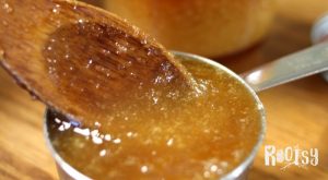 a cup of crystalized honey with a wooden spoon