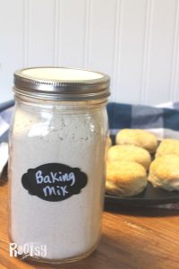 Jar of homemade biscuit baking mix and a pan of baked homemade biscuits in the background