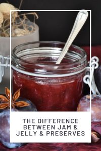 An open jar of jam with a spoon sticking out of it surrounded by plums and spices with text overlay stating: the difference between jam & jelly & preserves.