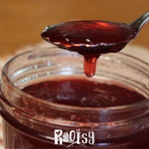 homemade plum jelly dripping off spoon
