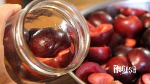 raw packing plum halves into a canning jar