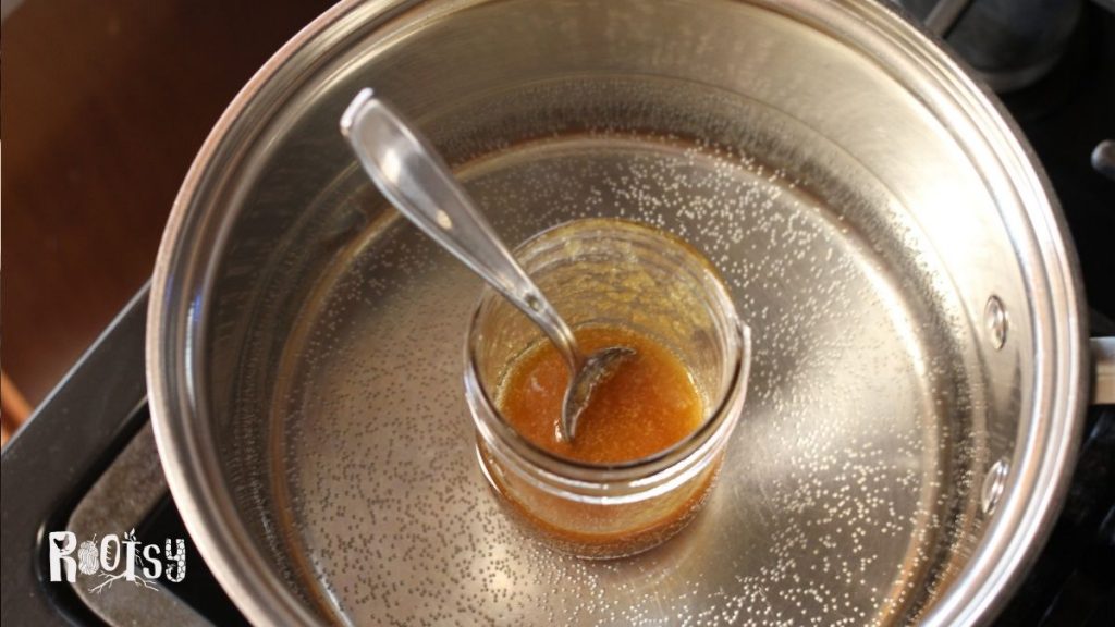 crystallized honey in mason jar in double boiler to decrystallize