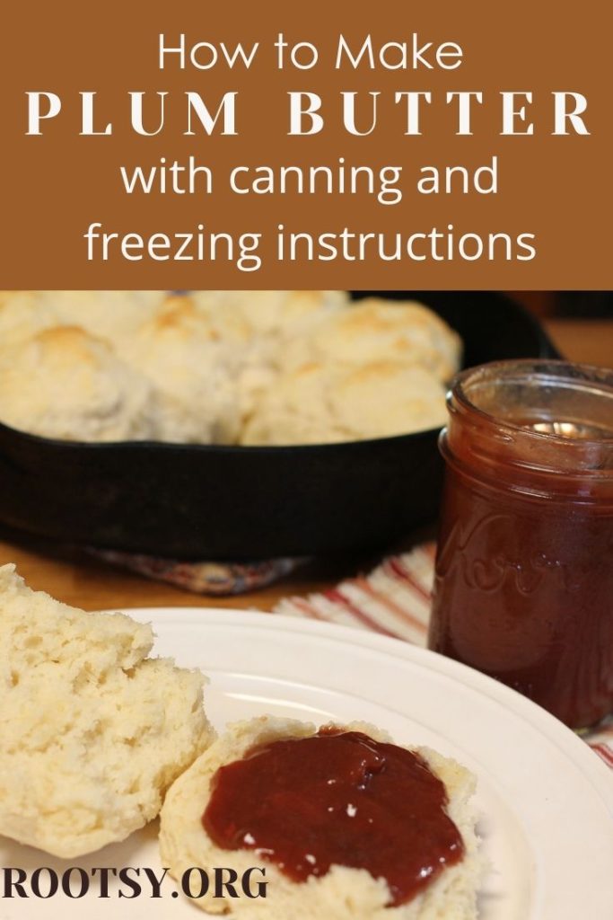 home canned plum butter on a biscuit with a cast iron skillet of biscuits in the background