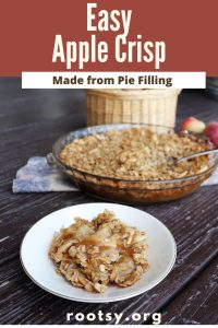 A bowl of apple crisp sits in front of the remaining pie plate full of apple crisp. Fresh apples and a basket sit in the background. Text overlay reads: Easy Apple Crisp made from pie filling.