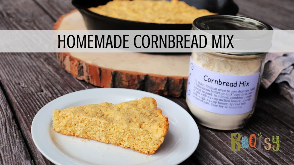 A slice of cornbread on a plate. A jar of cornbread mix sits behind it. A pan full of more cornbread in the background. Text overlay reads: Homemade Cornbread Mix.