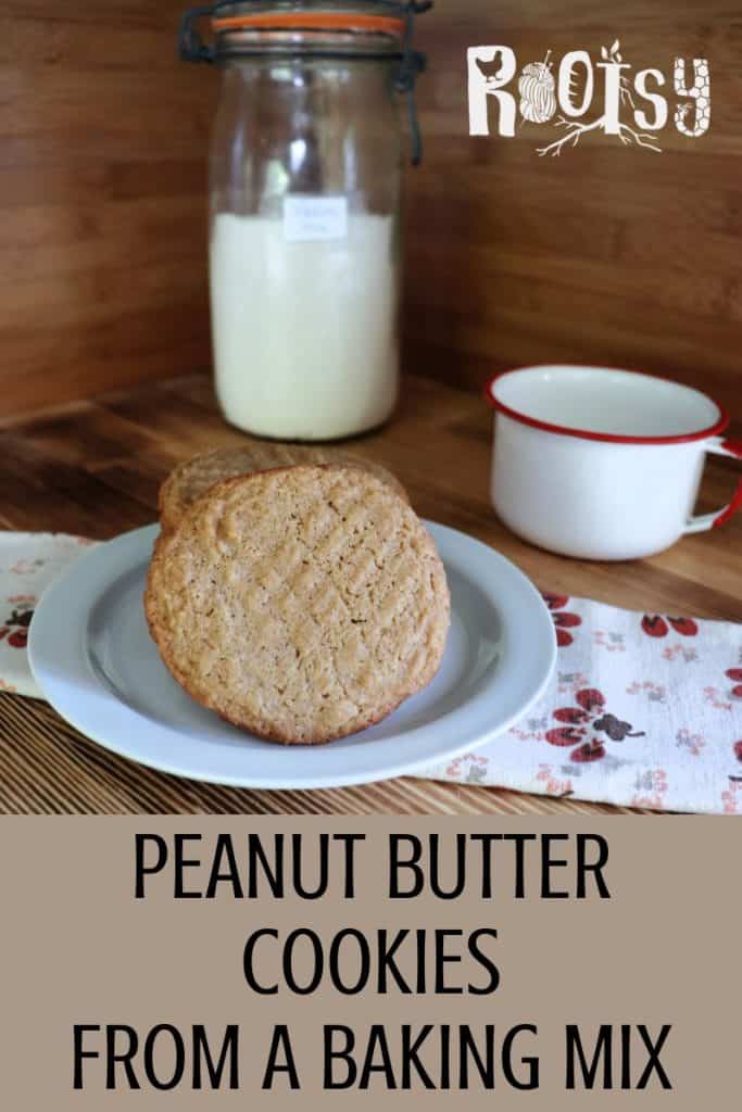 Two peanut butter cookies on a white plate next to a white mug and a glass jar of flour, with text overlay: "Peanut Butter Cookies From a Baking Mix" and "Rootsy" in the top right corner.