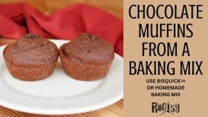 Two chocolate muffins on a white plate with a red cloth in the background. Text reads: "Chocolate Muffins from a Baking Mix. Use Bisquick™ or homemade baking mix. Rootsy.